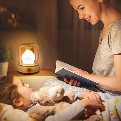 Maman lit l'histoire sous l'ombre d'une veilleuse bébé